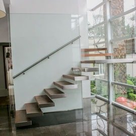 Guarda-corpo grande vidro único sustenta degraus escada.